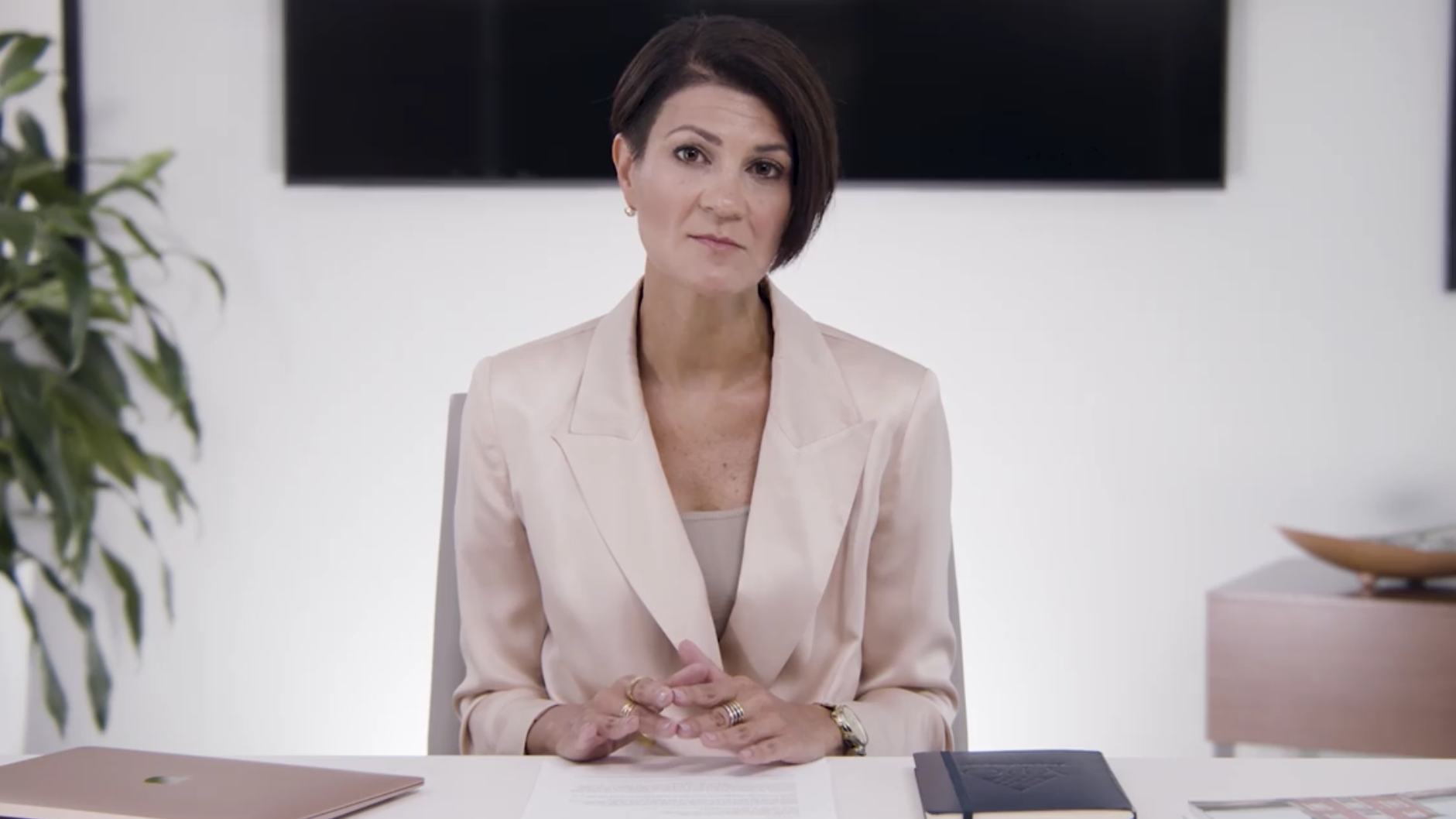 Sarah Davis sits behind a desk will giving her address