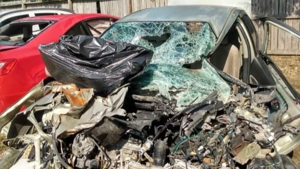 A mangled car with destroyed front end and shattered windshield
