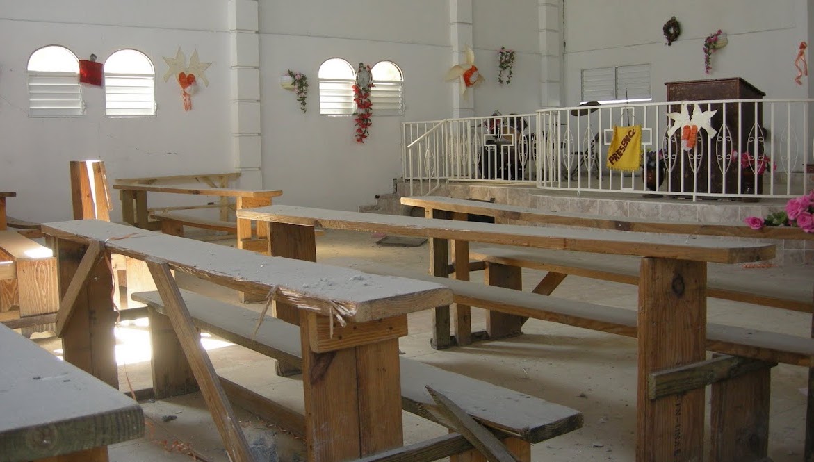An empty church sanctuary in Haiti. Pews are made out of rough lumber planks