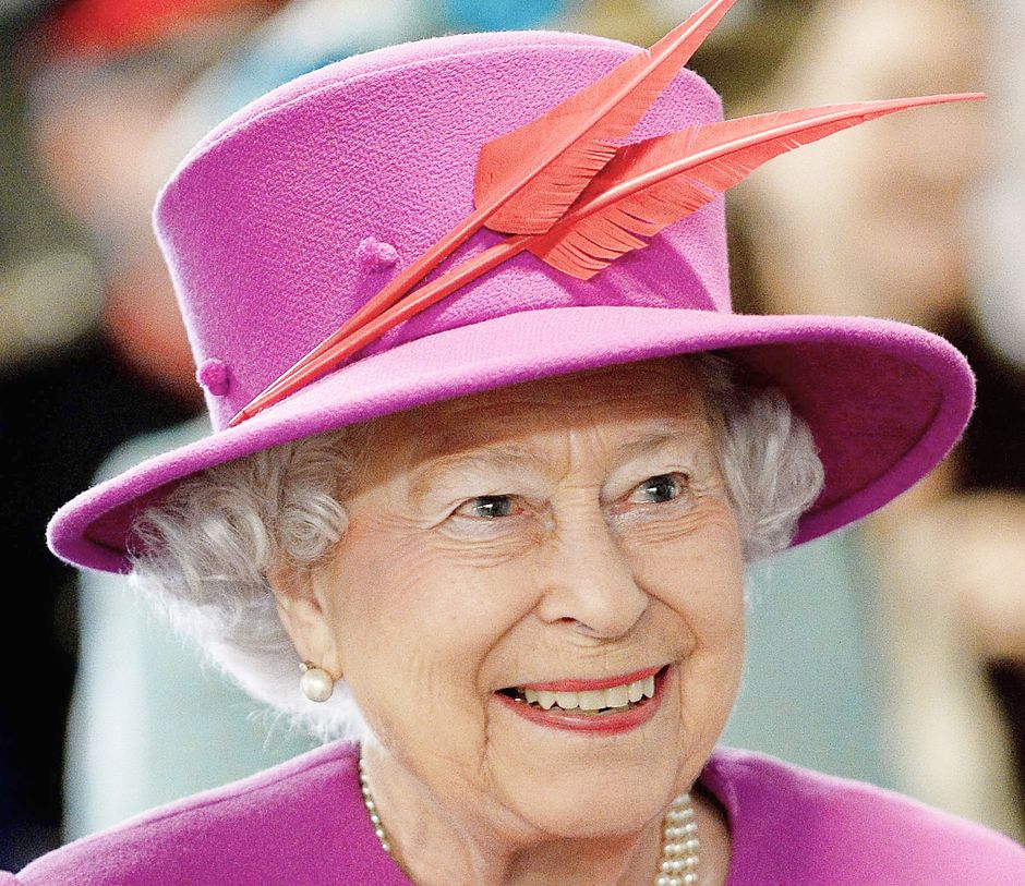 Queen Elizabeth wears a purple hat with 2 angled red feathers on the front
