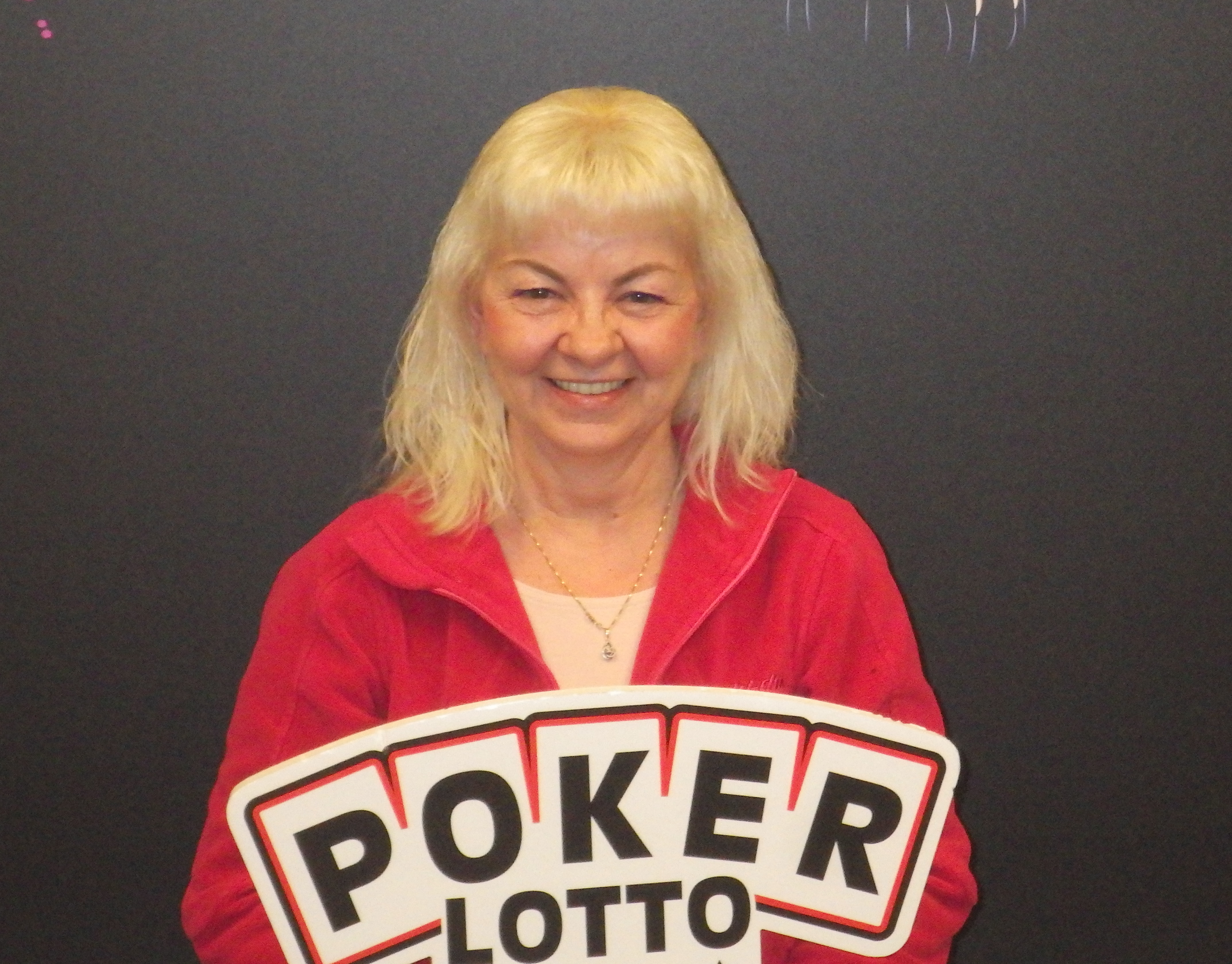 Brenda Schuster holding a POKER LOTTO sign.