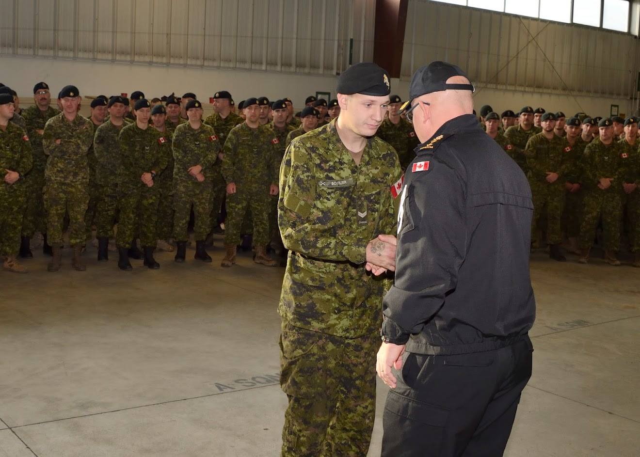 Jason Boutilier shaking hands while receiving a commendations.