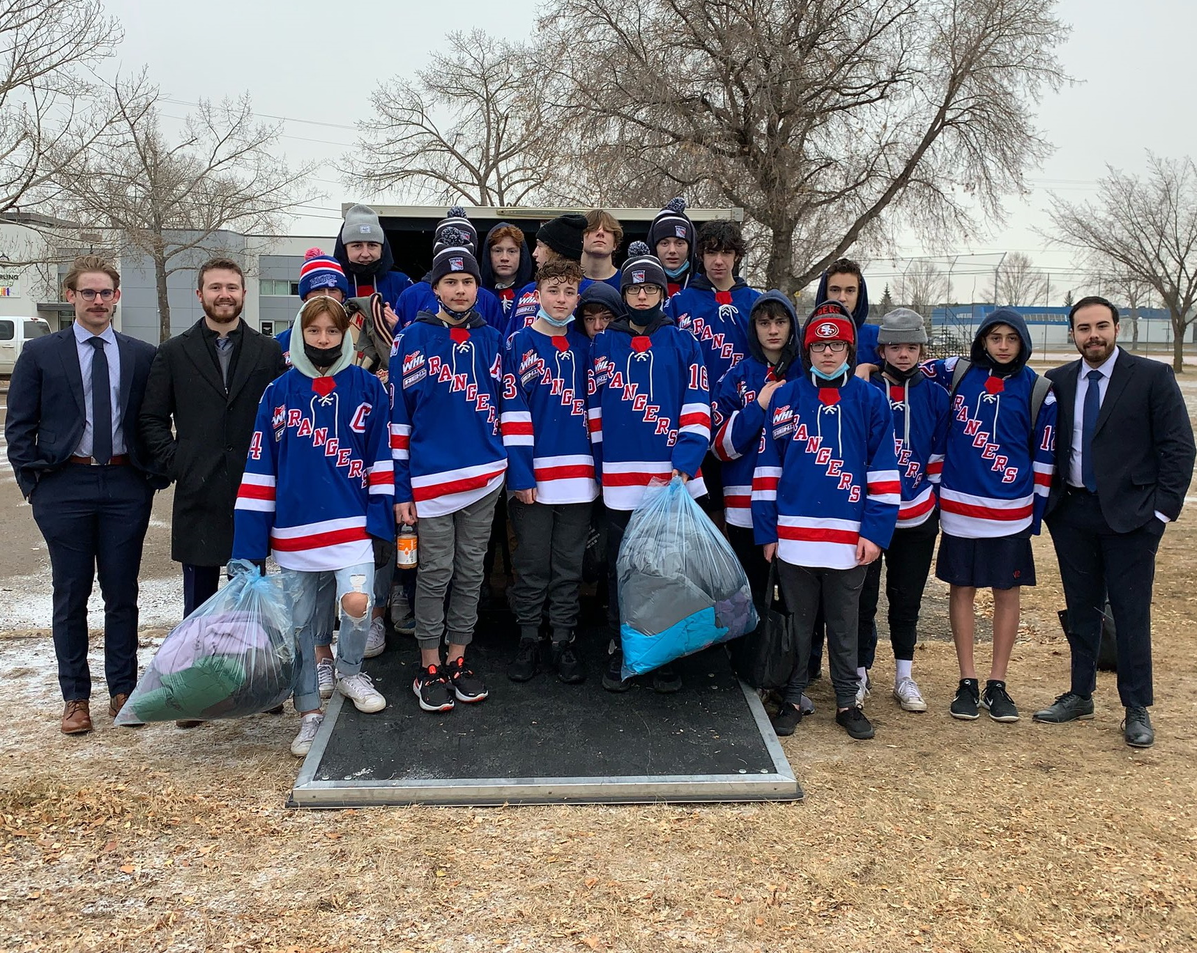 The U15 AAA Rangers posing with bags of clothes for their clothing drive.