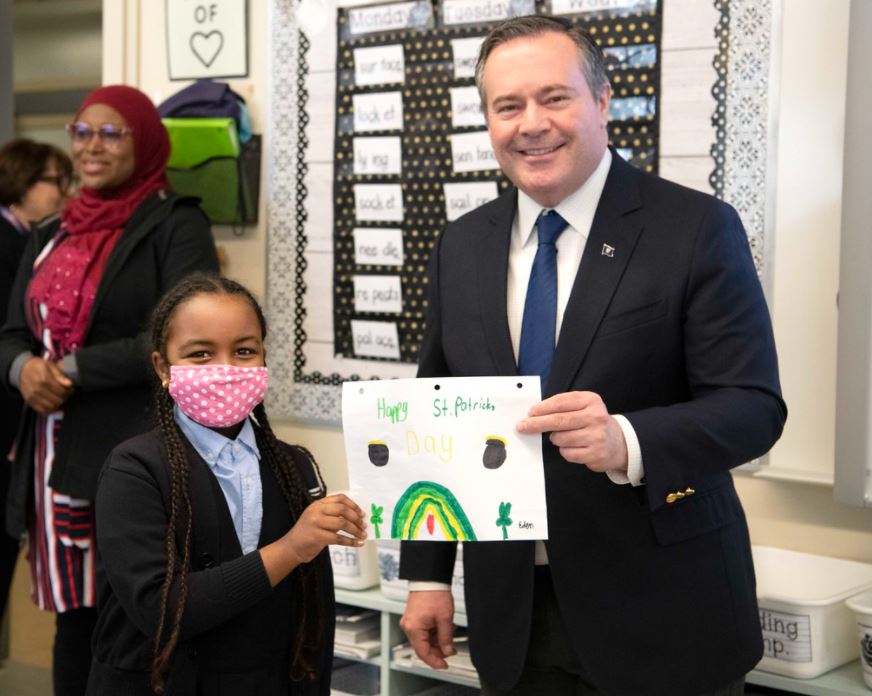 Premier Jason Kenney holding an art project with a student.