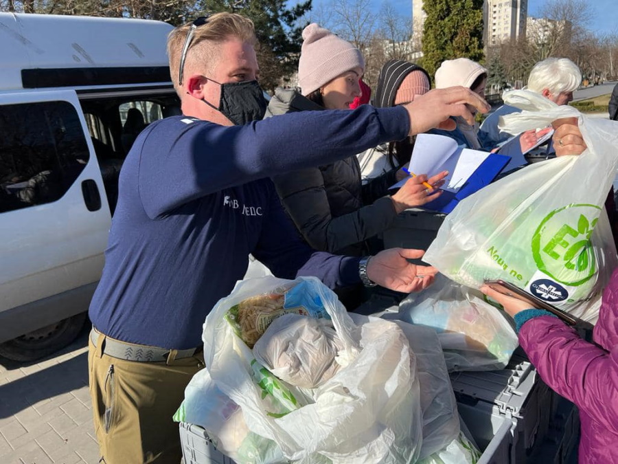Marc Pavan handing out food bags to refugees.