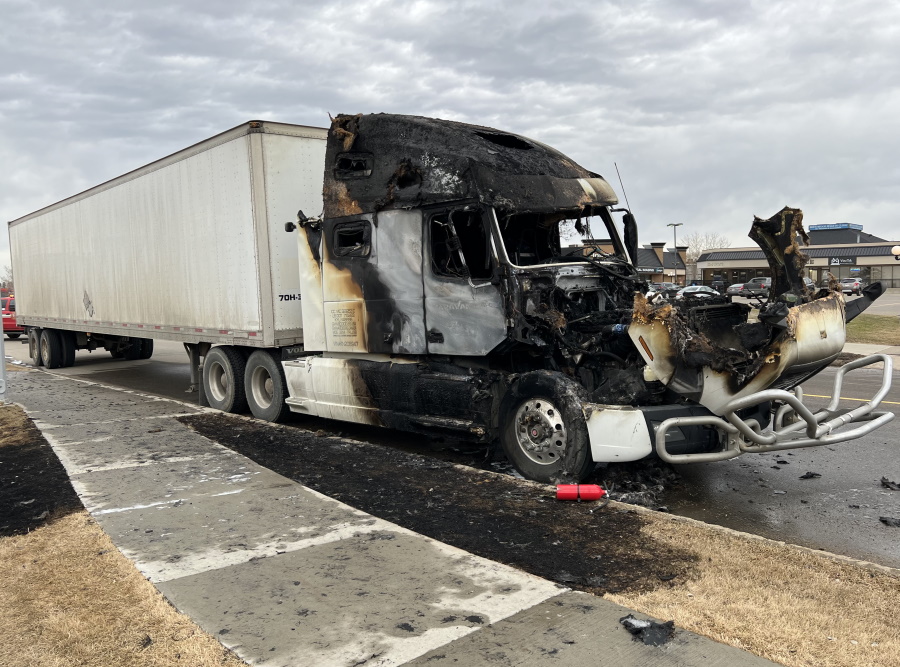 A burnt semi-truck on the road.