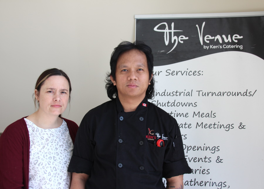Kelsey and Ken Dalida in front of a The Venue sign.
