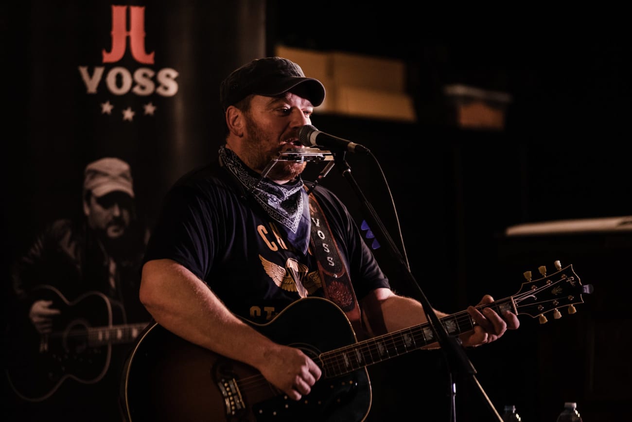 A man playing guitar and singing on stage.