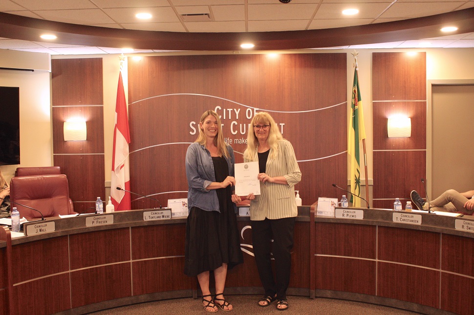 Two women holding a proclamation.