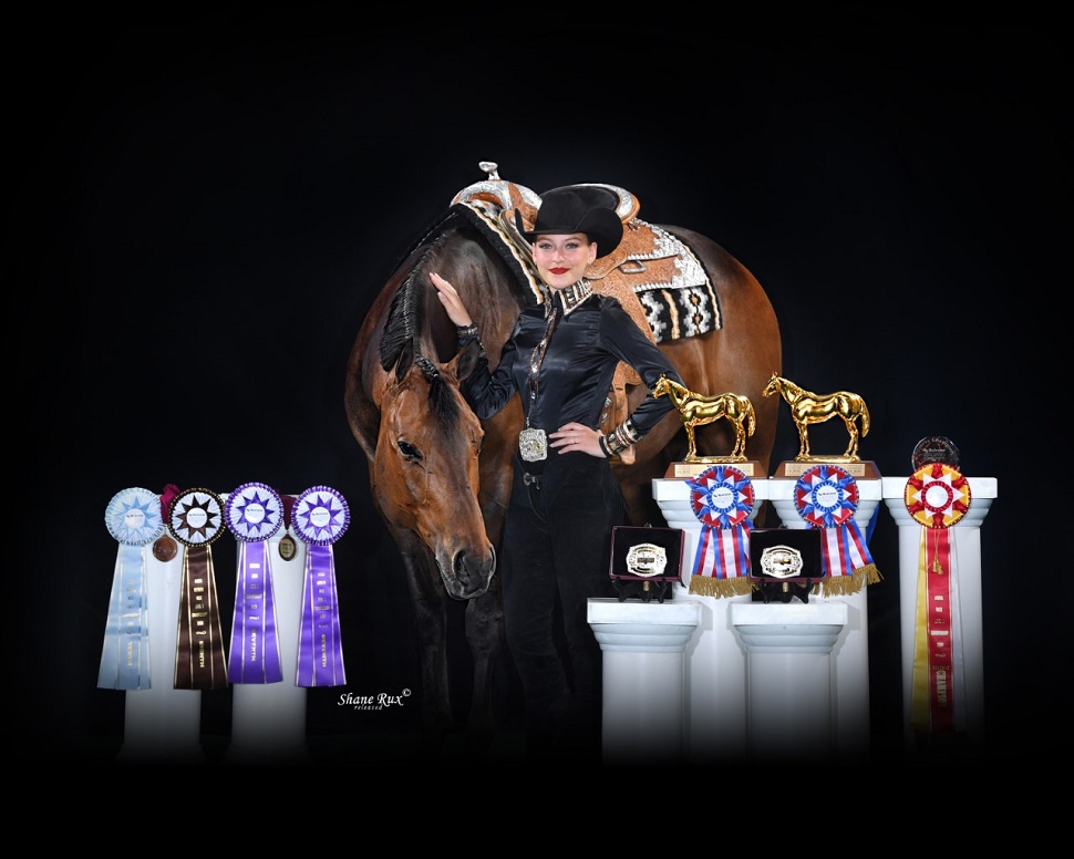 A young lady stands with her horse and numerous awards.