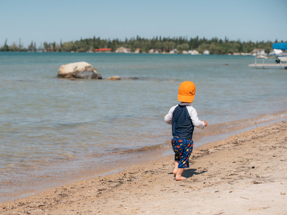 A little boy walks down the beach at Clearwater Lake