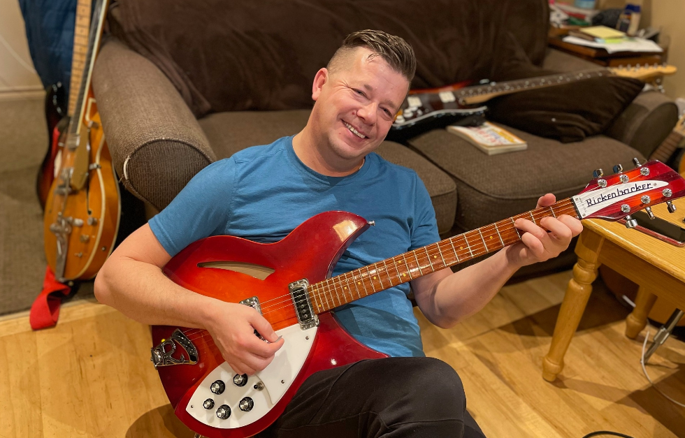 Jon Buller holding a guitar. 