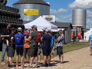 group of farmers at Ag in Motion standing in front of T-Bin display