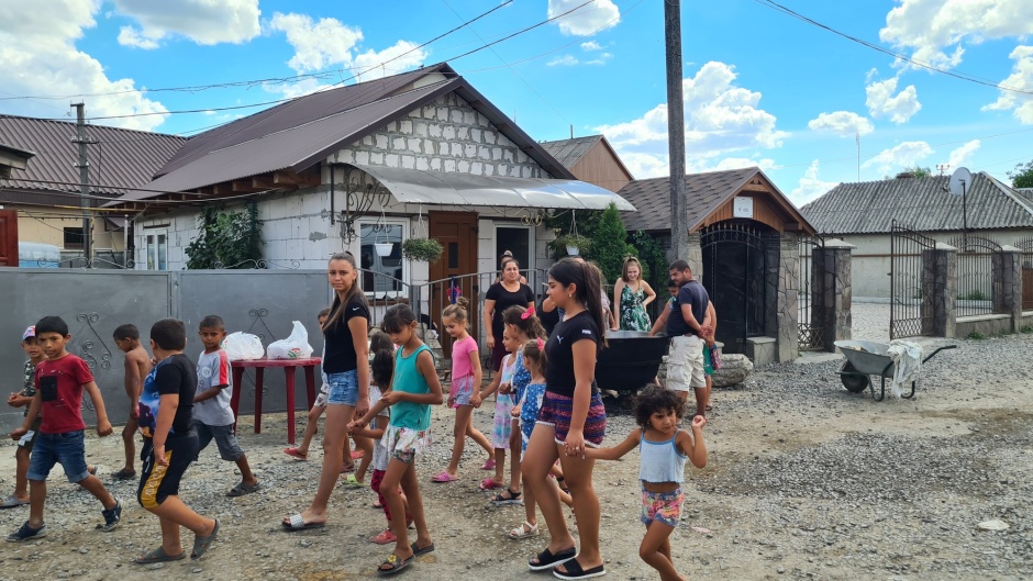 Some older girls walk with a group of children through a neighbourhood.