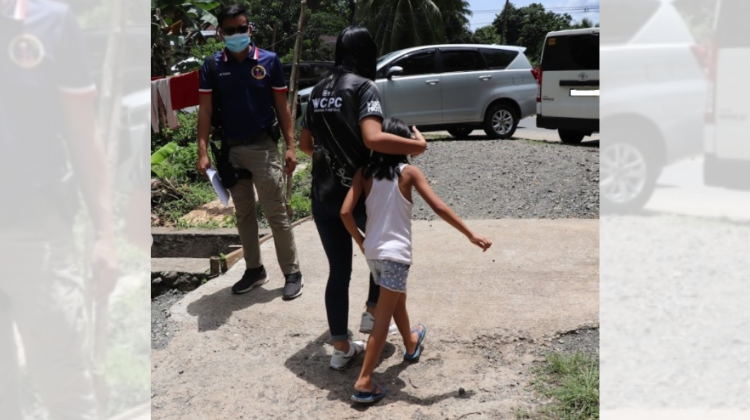 Philippine police with a child survivor of exploitation. 