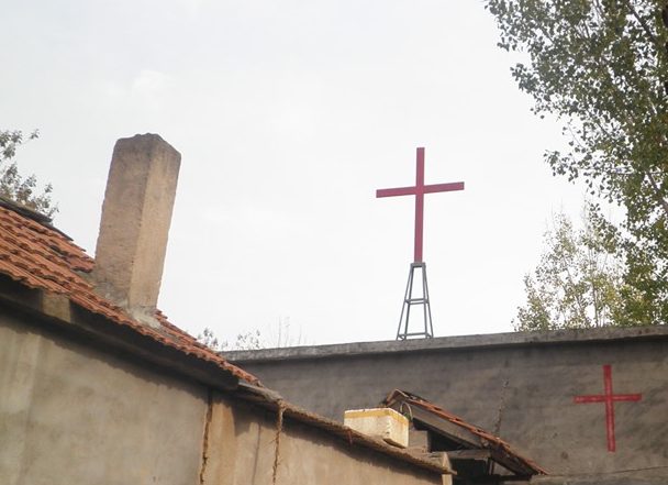 a roof of a small building with a red cross on top of it