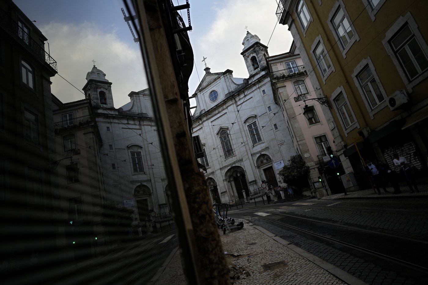 A photo of buildings taken from a low angle. a pane of glass street level reflects the buildings