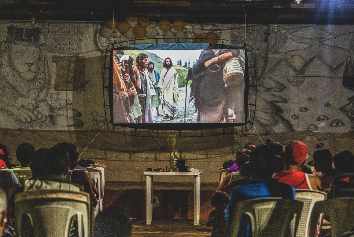 People in a village watching JESUS film in their own language. 