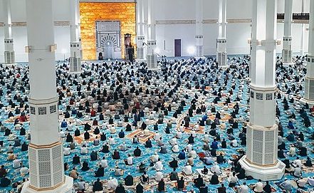 a large group of people worship in a mosque