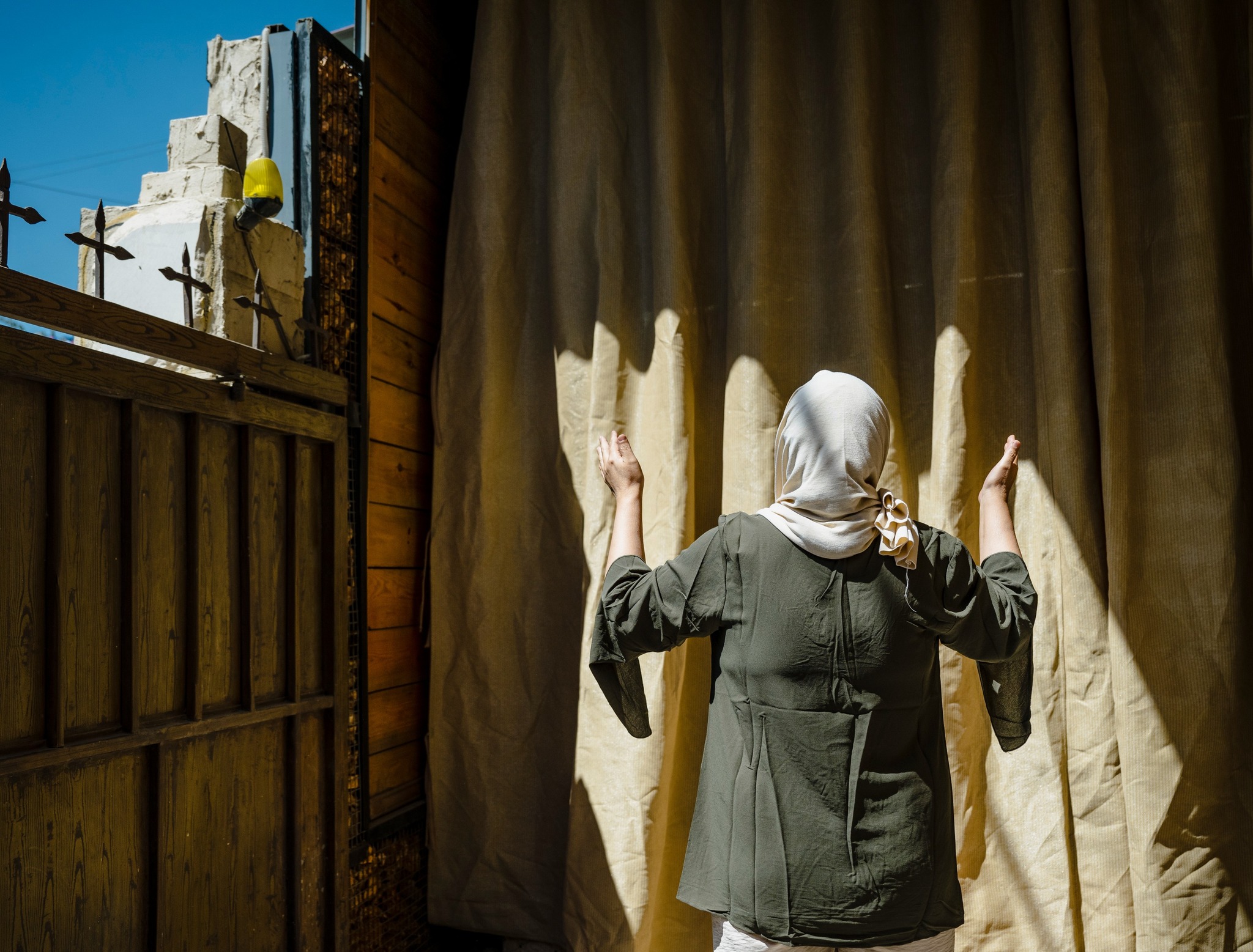 a woman holds hands up in prayer