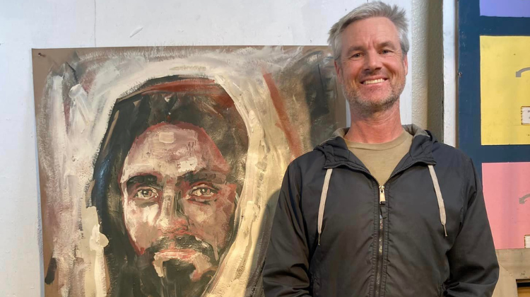 Matt Harward standing next to painting of Jesus (fb)