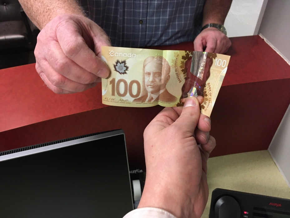 a person handing another person a $100 bill