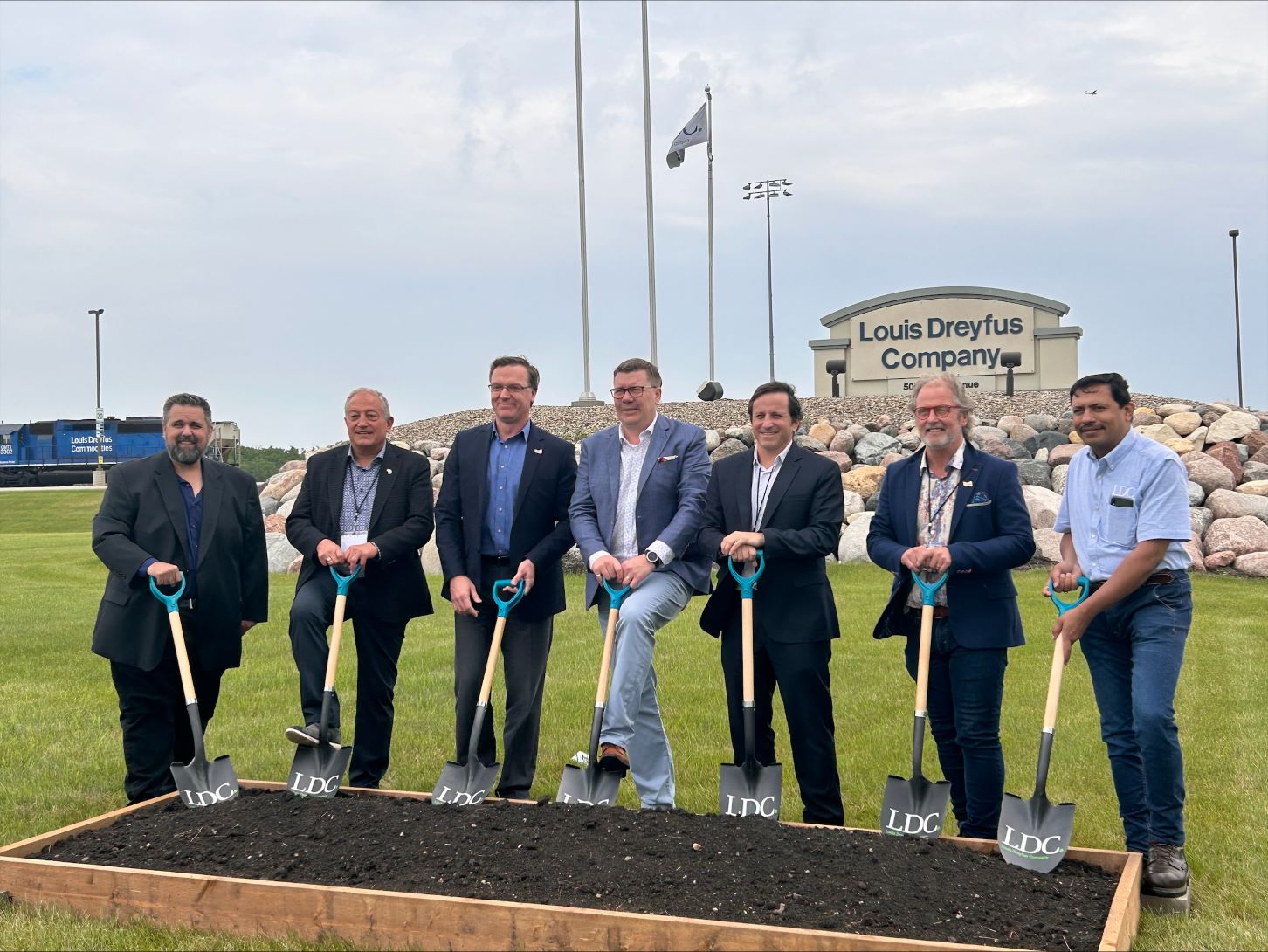 Premier Moe and other officials standing with shovels in front of Louis Dreyfus sign for sod turning event