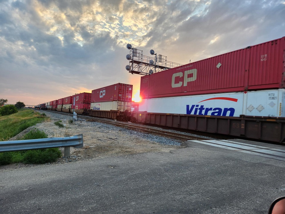 The sun beaming in between train cars.