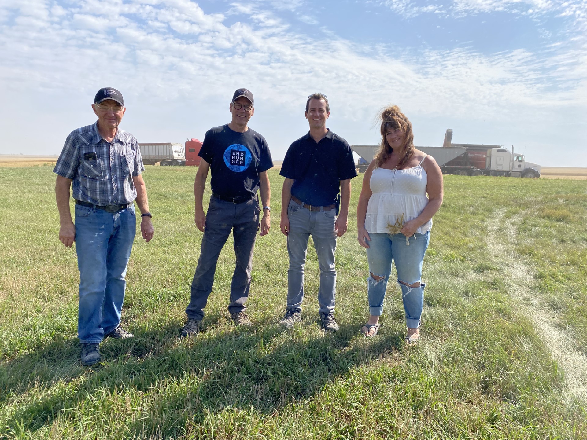 Four people standing out in a pasture