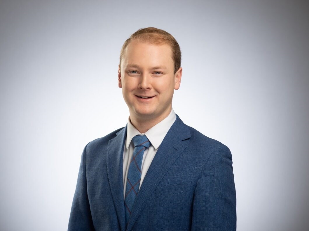 a young man in a suit smiling