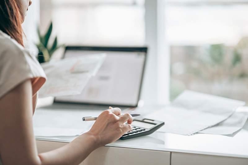 a lady sitting at a computer using a calculator