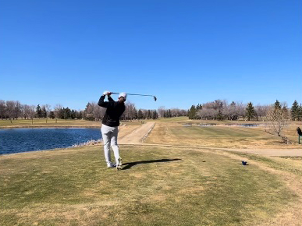 a man watches his ball after taking a swing on the golf course