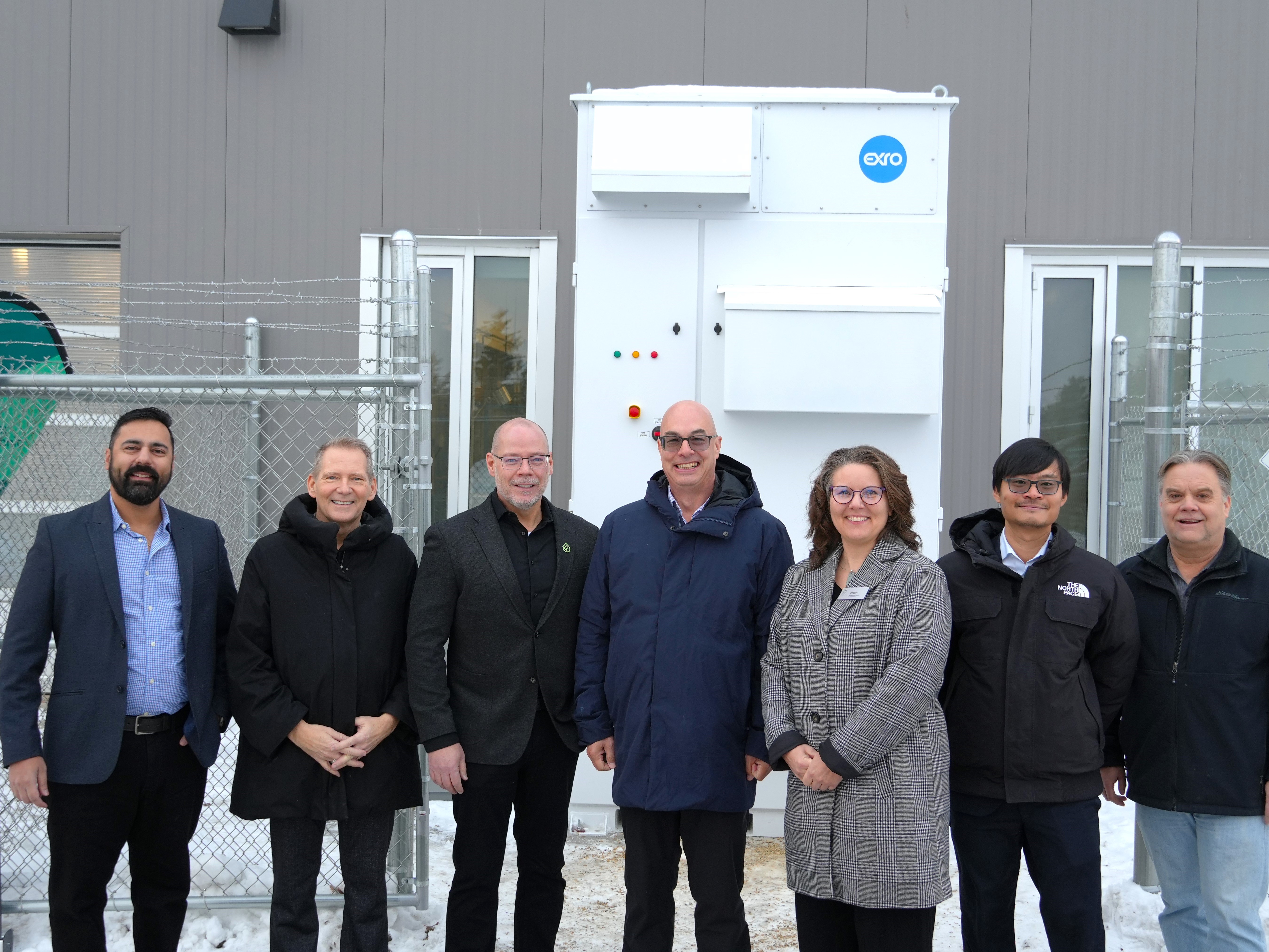 Representatives from RDP and Exro Technologies stand in front of the First Cell Driver™ Energy Storage System.