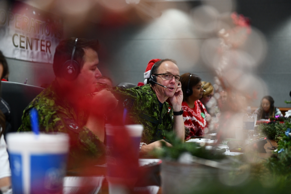 A man in camoflage talking on the phone