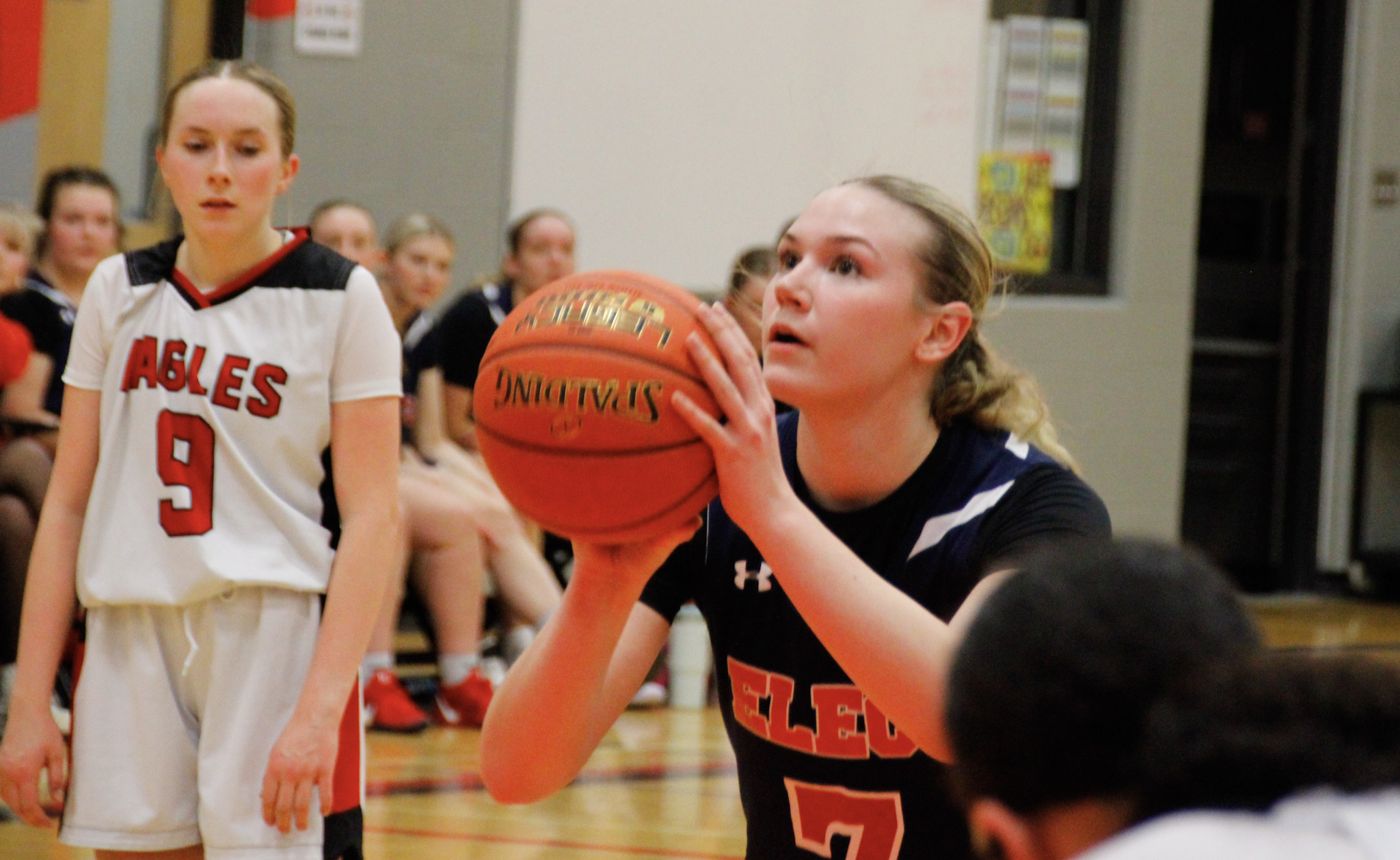 A basketball game between teams in dark blue and red
