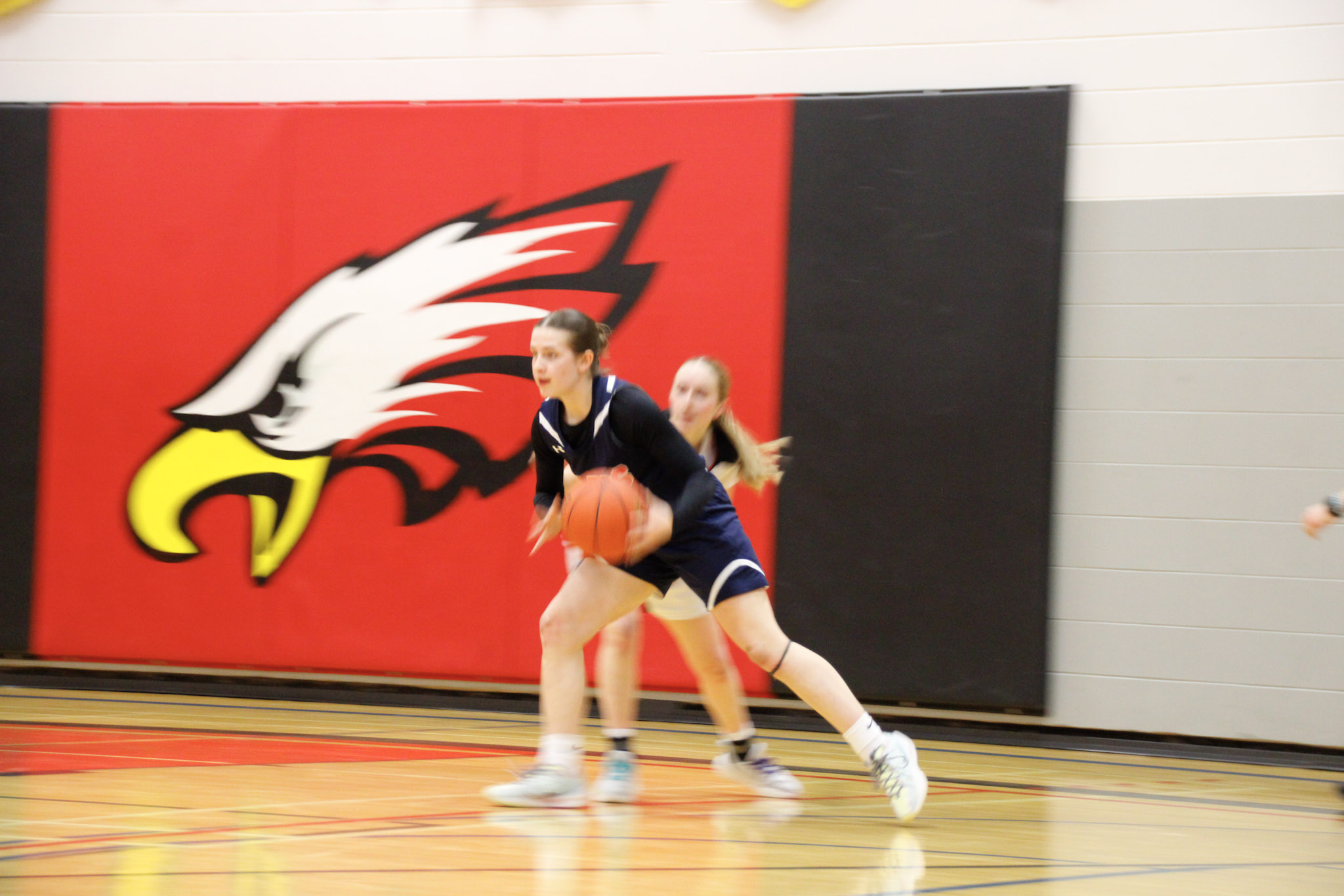A basketball game between teams in dark blue and red