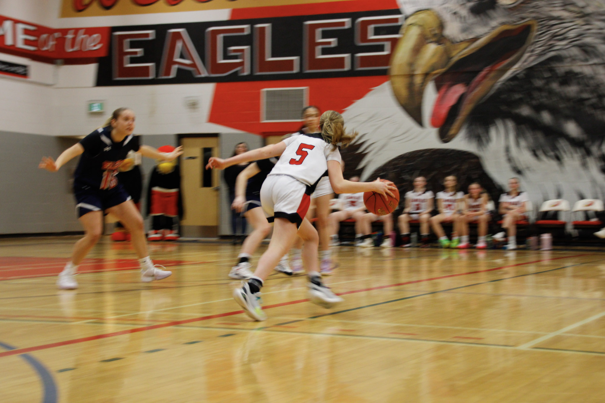 A basketball game between teams in dark blue and red