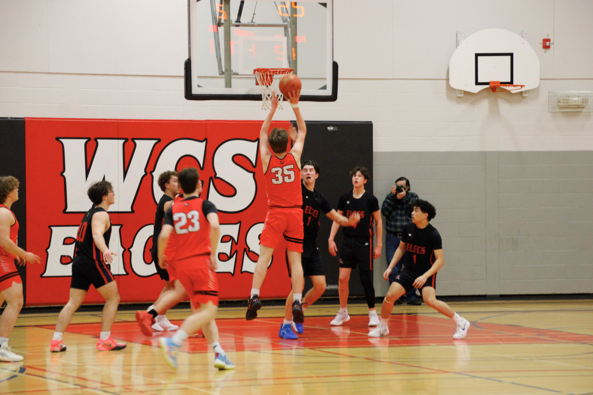 A basketball game between teams in dark blue and red
