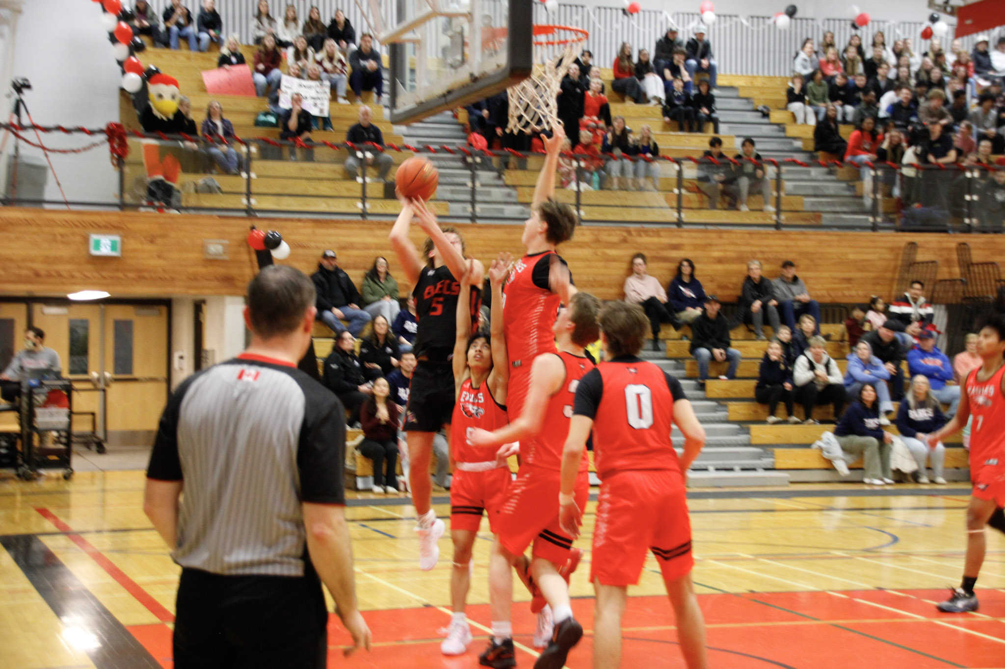 A basketball game between teams in dark blue and red