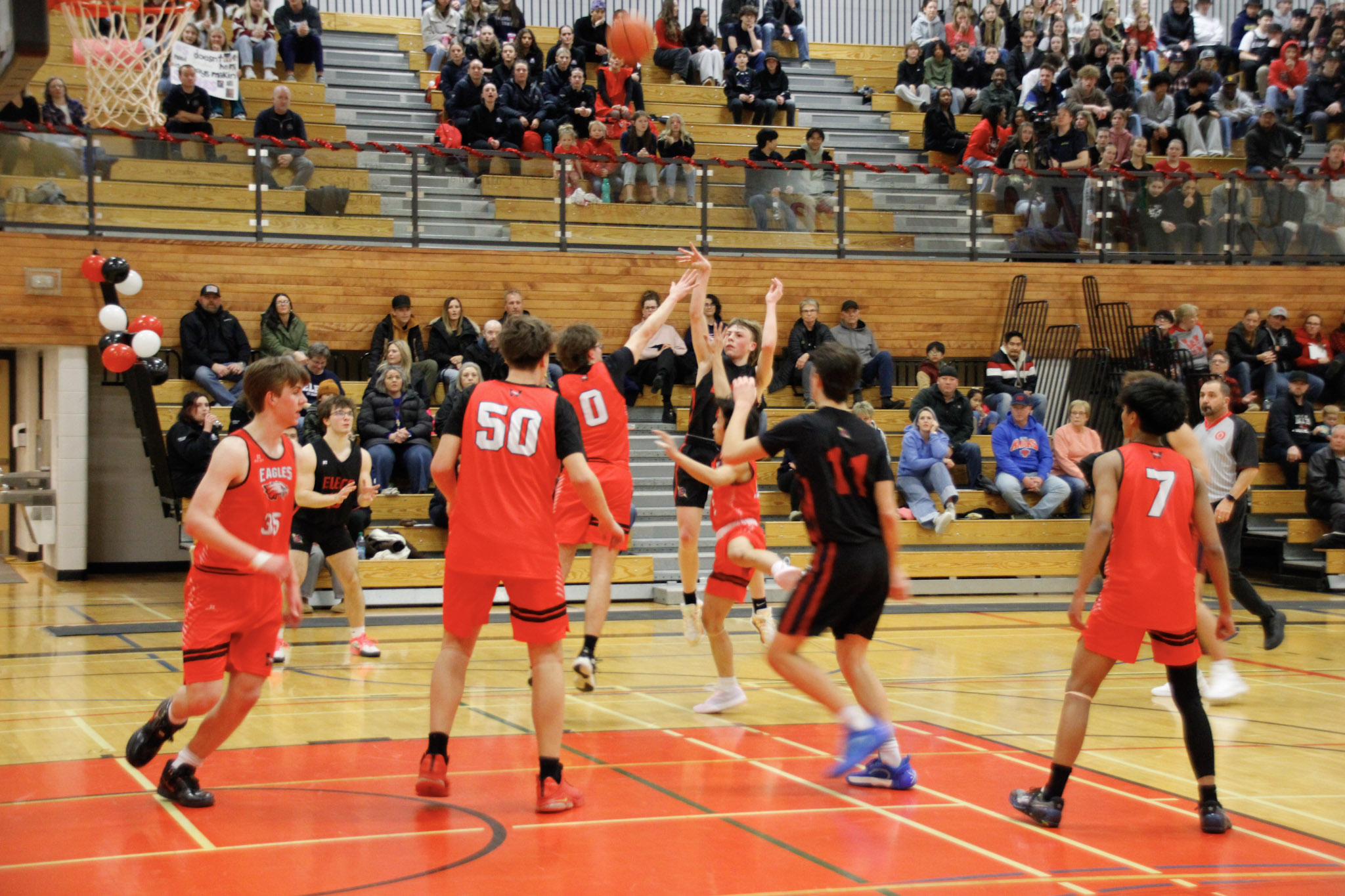 A basketball game between teams in dark blue and red