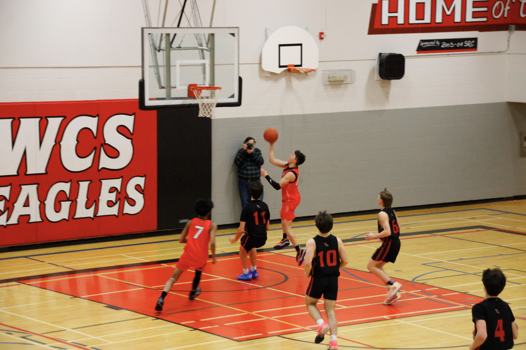 A basketball game between teams in dark blue and red