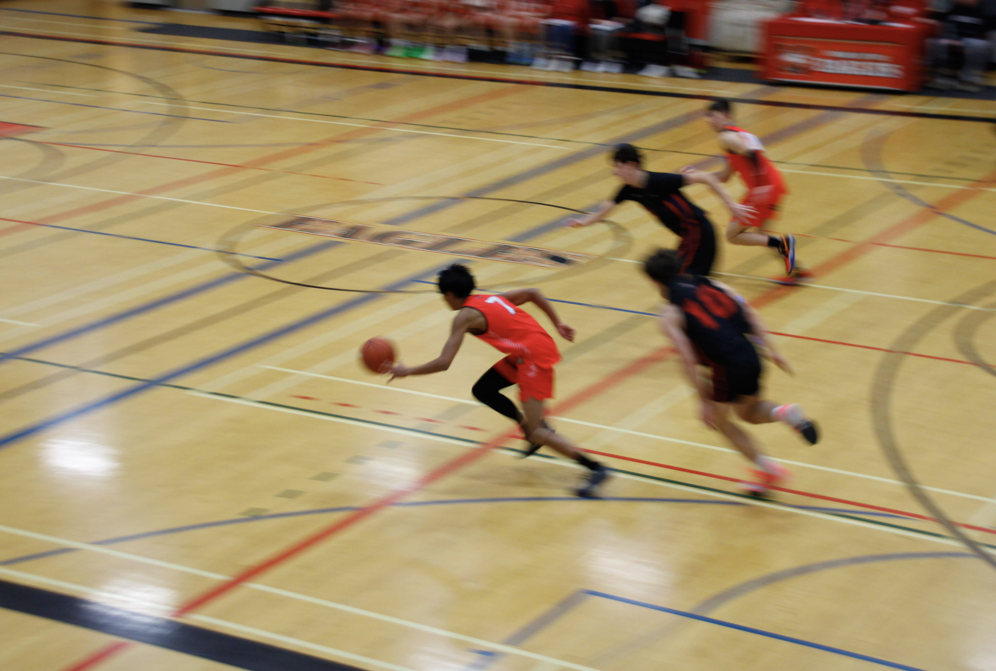 A basketball game between teams in dark blue and red