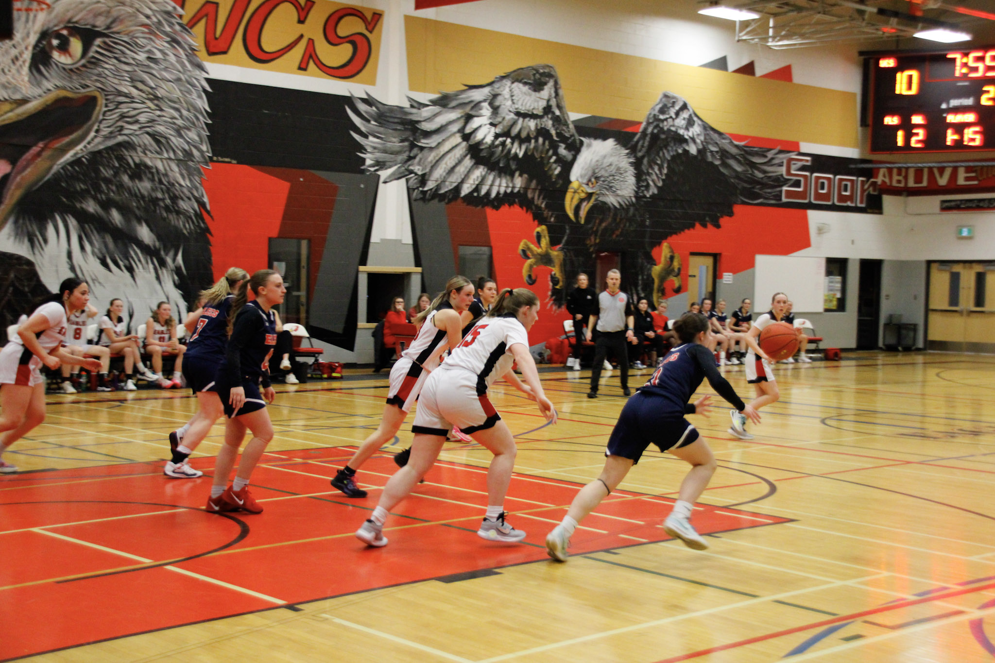 A basketball game between teams in dark blue and red