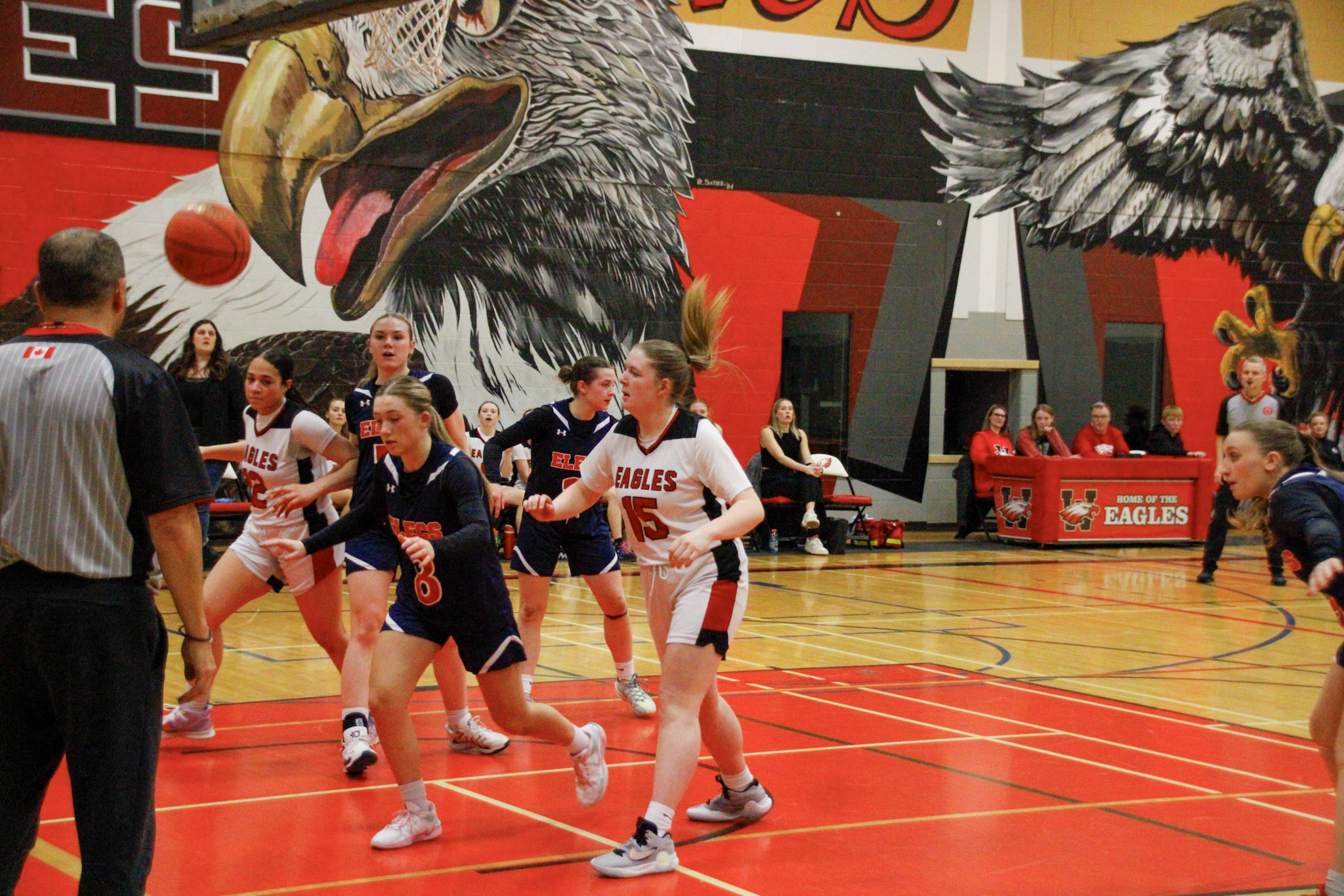 A basketball game between teams in dark blue and red