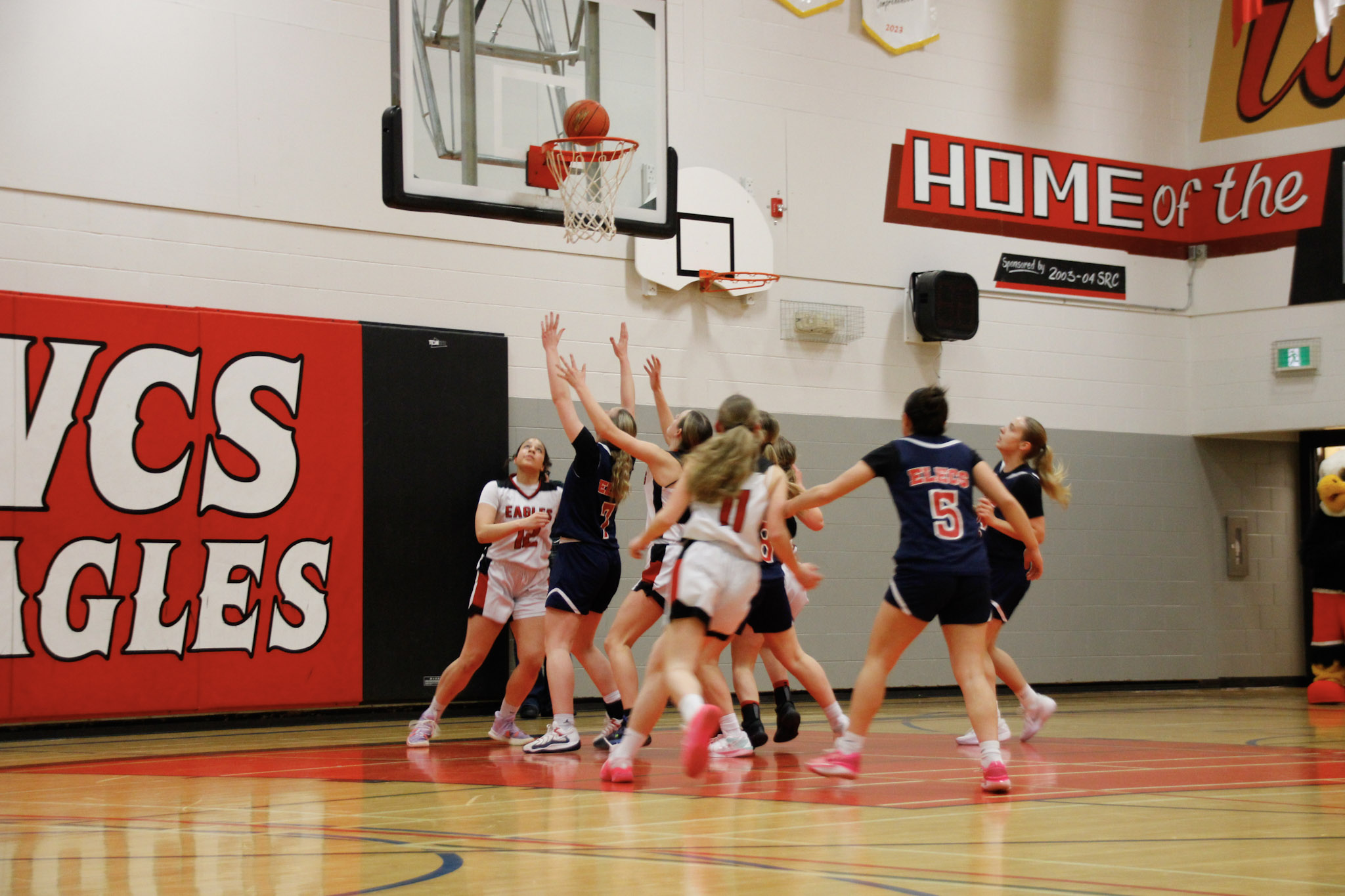 A basketball game between teams in dark blue and red