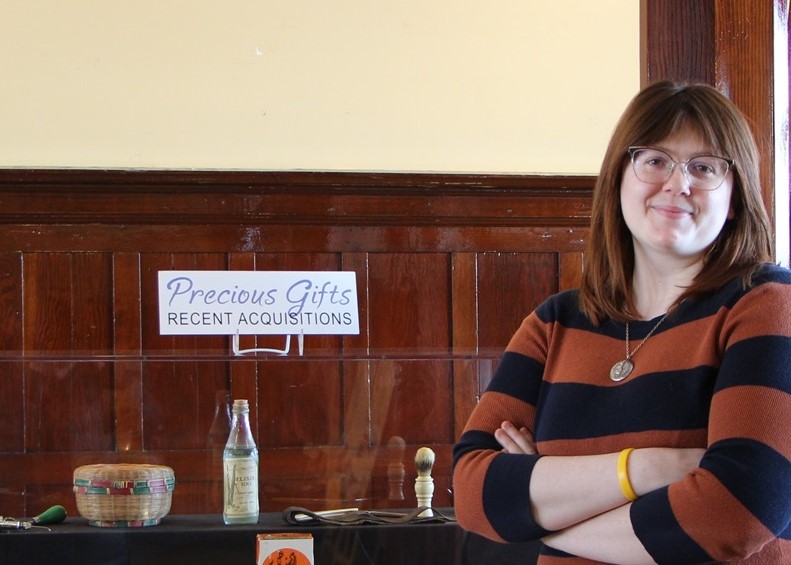 Olivia Cotton Cornwall, the new curator at the Museum of the Highwood, stands beside the new acquisitions display. High River Online/Kevin Wallace