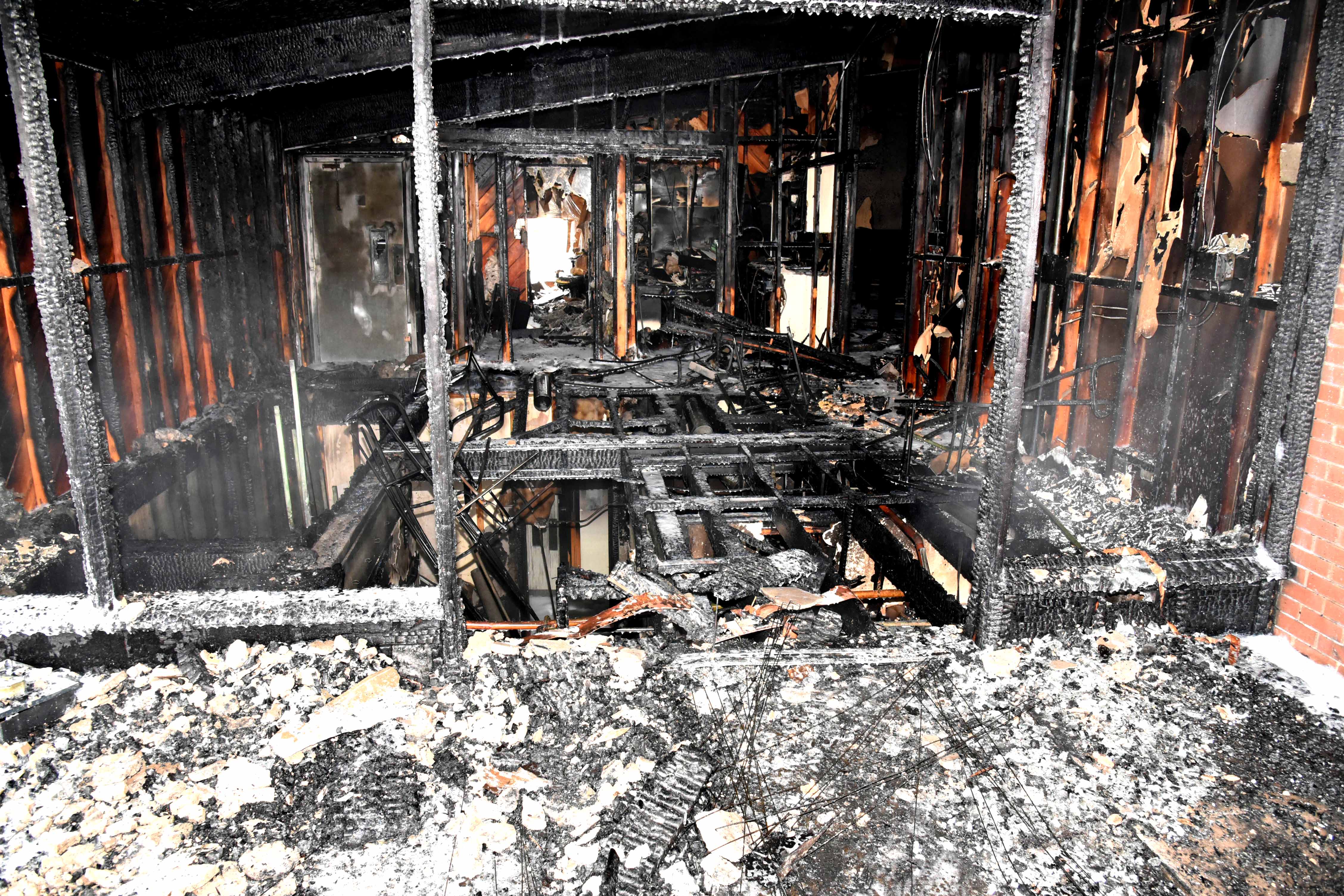 a burned out church building - the middle of the floor is completely collapsed. walls are just charred lumber