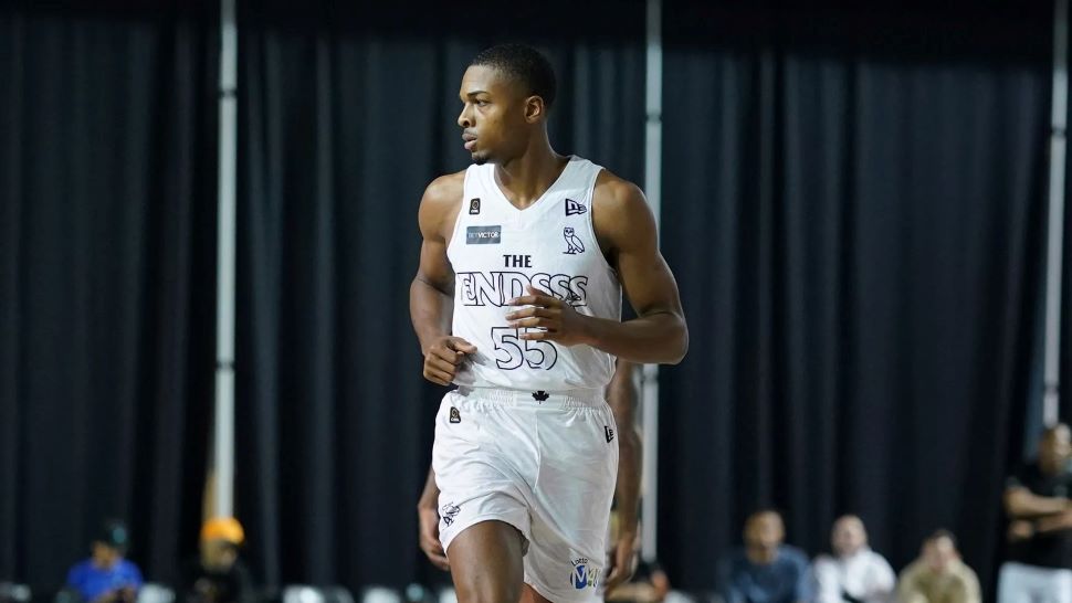 A basketball player looks to his side while running down the court