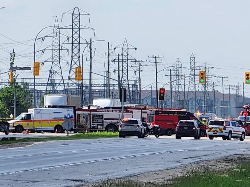 Several emergency vehicles are on both sides of a 4-lane road