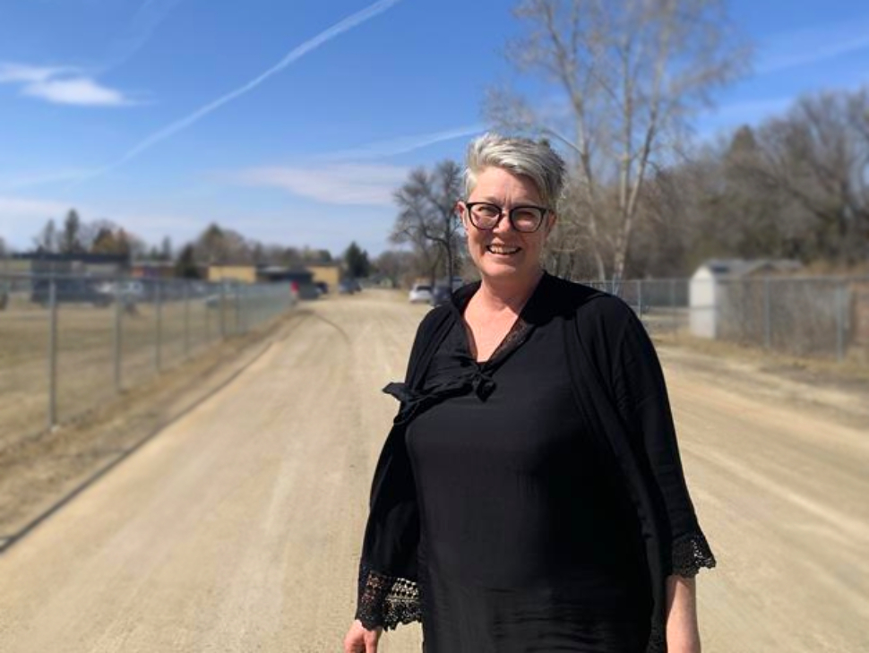 Marge thiessen stands in the bus lane at Southwood Elementary School